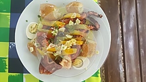 View of a typical Portuguese meal, dish with grilled octopus, potato, egg and garlic, in Portugal it is called polvo ÃÂ  lagareiro photo